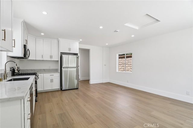 17043 Celtic St, Granada Hills, CA 91344 - kitchen featuring stainless steel appliances, recessed lighting, white cabinetry, light wood finished floors, and light stone countertops
