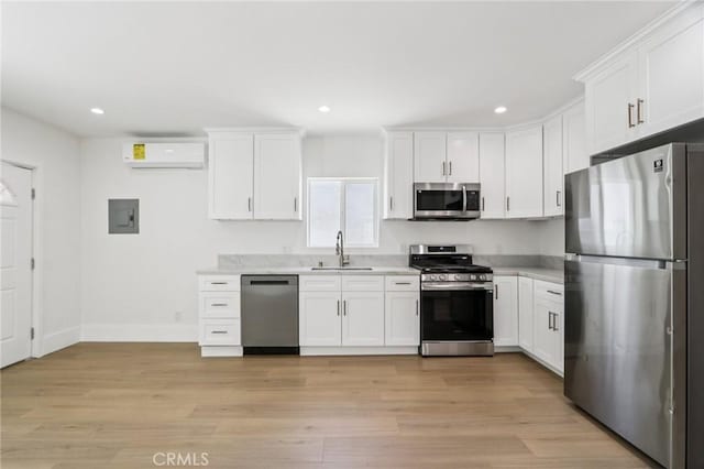 17043 Celtic St, Granada Hills, CA 91344 - kitchen featuring appliances with stainless steel finishes, electric panel, a wall mounted air conditioner, white cabinetry, and recessed lighting