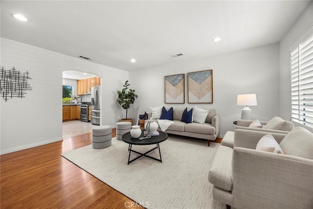4161 E Fauna Ave, Anaheim, CA 92807 - living room with arched walkways, light wood-style flooring, and recessed lighting