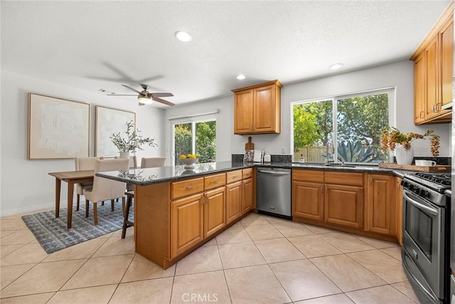 4161 E Fauna Ave, Anaheim, CA 92807 - kitchen featuring appliances with stainless steel finishes, a peninsula, brown cabinets, ceiling fan, and recessed lighting
