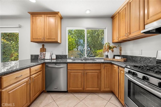 4161 E Fauna Ave, Anaheim, CA 92807 - kitchen with appliances with stainless steel finishes, dark stone counters, light tile patterned floors, under cabinet range hood, and brown cabinets
