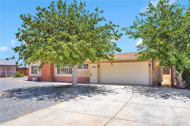 21815 Jelan Ave, Apple Valley, CA 92307 - view of property hidden behind natural elements with an attached garage, concrete driveway, and stucco siding