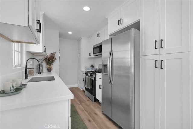 21815 Jelan Ave, Apple Valley, CA 92307 - kitchen with appliances with stainless steel finishes, light wood finished floors, white cabinets, recessed lighting, and light countertops