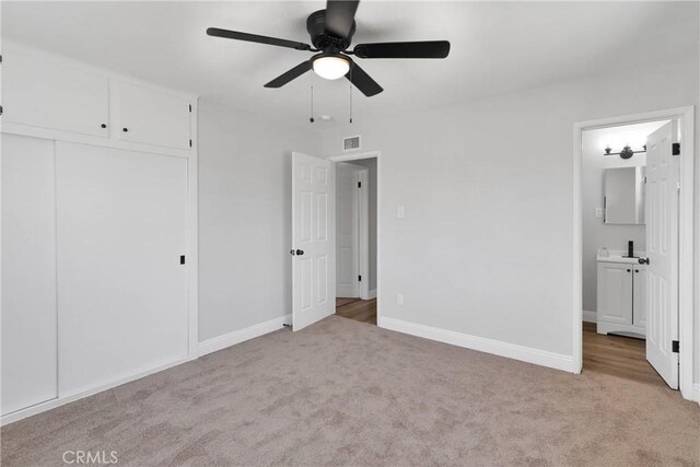21815 Jelan Ave, Apple Valley, CA 92307 - unfurnished bedroom featuring light colored carpet, ensuite bath, a closet, and a ceiling fan