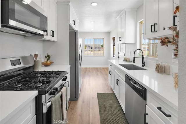 21815 Jelan Ave, Apple Valley, CA 92307 - kitchen with appliances with stainless steel finishes, light wood finished floors, white cabinetry, light countertops, and recessed lighting