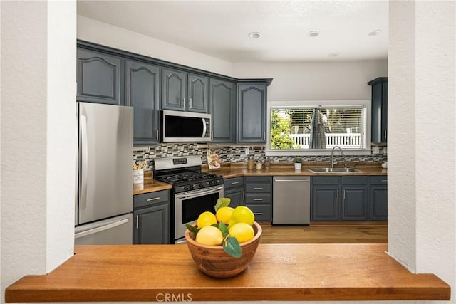 24343 Landover Rd Unit 139, Laguna Hills, CA 92653 - kitchen with stainless steel appliances, decorative backsplash, light wood-style floors, gray cabinets, and a textured wall
