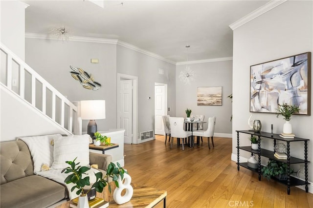 24343 Landover Rd Unit 139, Laguna Hills, CA 92653 - living room featuring stairway, light wood-style floors, ornamental molding, and a chandelier