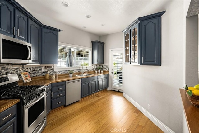 24343 Landover Rd Unit 139, Laguna Hills, CA 92653 - kitchen featuring stainless steel appliances, decorative backsplash, light wood-style floors, glass insert cabinets, and recessed lighting