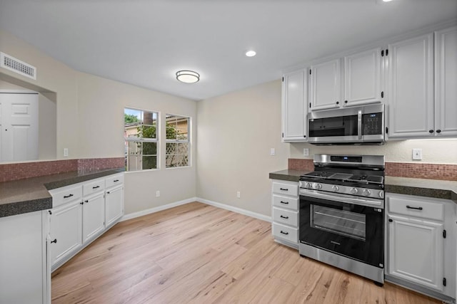 4625 Los Alamos Way Unit C, Oceanside, CA 92057 - kitchen with appliances with stainless steel finishes, light wood-style flooring, white cabinets, dark countertops, and recessed lighting