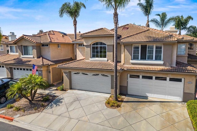 4625 Los Alamos Way Unit C, Oceanside, CA 92057 - view of front of property featuring concrete driveway, stucco siding, an attached garage, and a tiled roof