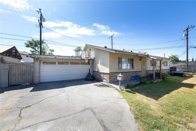 5082 La Madera Ave, El Monte, CA 91732 - view of front of home with a trampoline, stucco siding, driveway, stone siding, and a gate