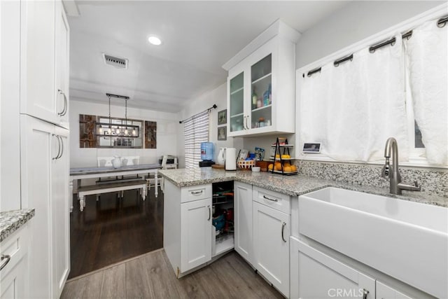 5082 La Madera Ave, El Monte, CA 91732 - kitchen with dark wood finished floors, white cabinets, glass insert cabinets, a peninsula, and recessed lighting