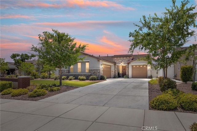 14217 Pemberley Passage Ave, Bakersfield, CA 93311 - view of front facade with stone siding, a garage, driveway, stucco siding, and a tiled roof