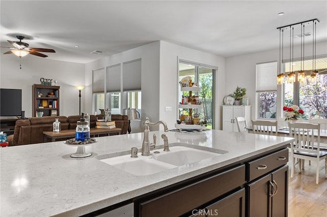 14217 Pemberley Passage Ave, Bakersfield, CA 93311 - kitchen featuring light stone countertops, open floor plan, plenty of natural light, and a ceiling fan