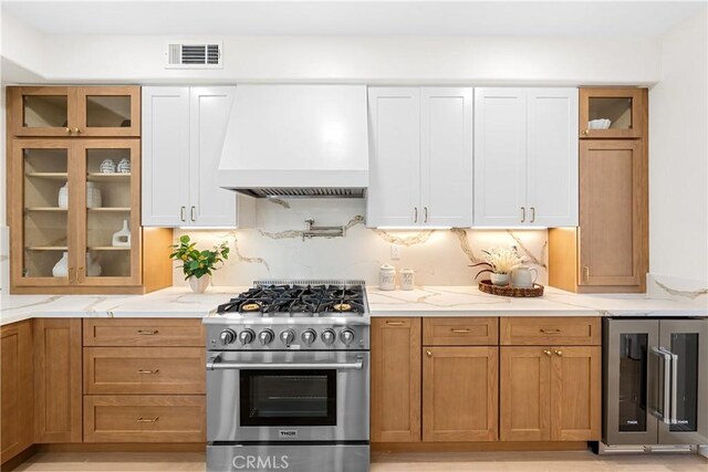 15 Lyon Rdg, Aliso Viejo, CA 92656 - kitchen featuring wine cooler, custom exhaust hood, high end stainless steel range, and light stone countertops