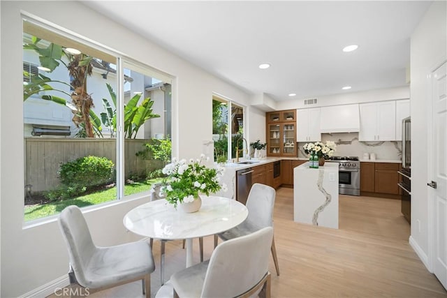 15 Lyon Rdg, Aliso Viejo, CA 92656 - kitchen with high end appliances, a kitchen island, light wood-style floors, recessed lighting, and white cabinetry