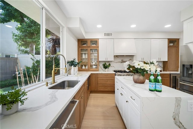 15 Lyon Rdg, Aliso Viejo, CA 92656 - kitchen with custom exhaust hood, glass insert cabinets, white cabinets, light stone countertops, and recessed lighting