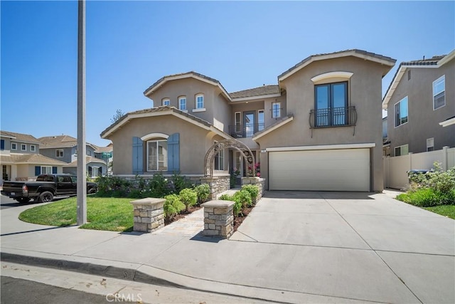 15 Lyon Rdg, Aliso Viejo, CA 92656 - mediterranean / spanish house featuring a balcony, stucco siding, an attached garage, driveway, and french doors