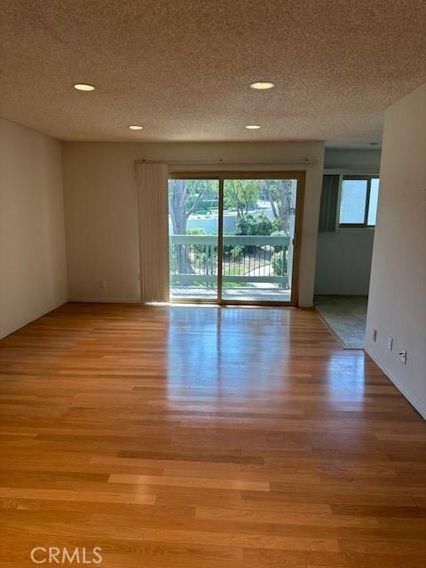 23675 Park Capri Unit 24, Calabasas, CA 91302 - unfurnished room featuring healthy amount of natural light, light wood-type flooring, a textured ceiling, and recessed lighting