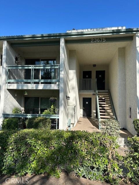 23675 Park Capri Unit 24, Calabasas, CA 91302 - property entrance featuring a balcony and stucco siding