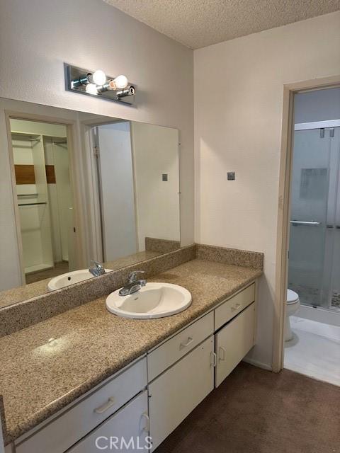 23675 Park Capri Unit 24, Calabasas, CA 91302 - bathroom featuring vanity, a stall shower, and a textured ceiling