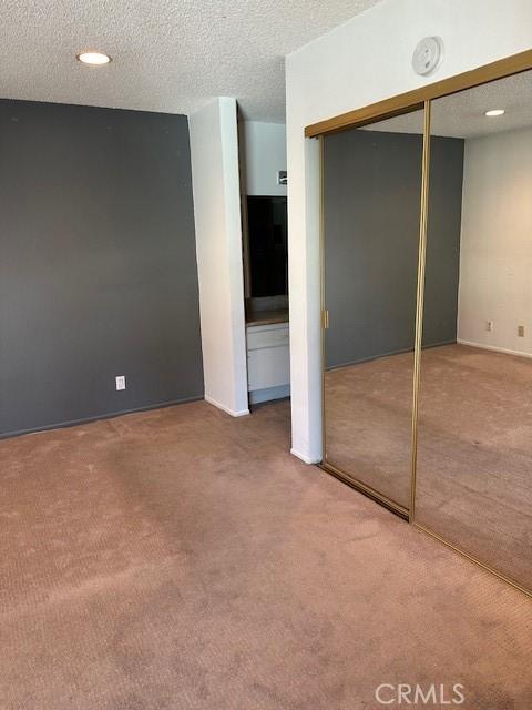 23675 Park Capri Unit 24, Calabasas, CA 91302 - unfurnished bedroom with carpet, a textured ceiling, and a closet