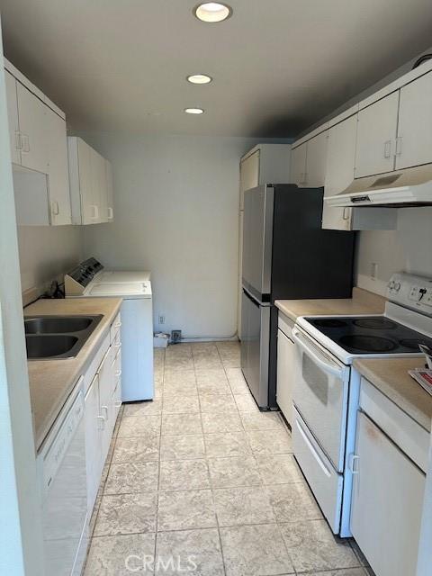 23675 Park Capri Unit 24, Calabasas, CA 91302 - kitchen with white appliances, under cabinet range hood, washer / clothes dryer, light countertops, and recessed lighting