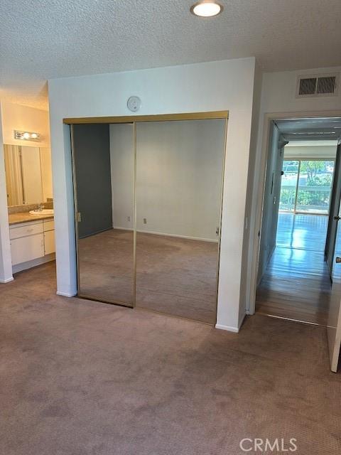 23675 Park Capri Unit 24, Calabasas, CA 91302 - unfurnished bedroom with carpet, a textured ceiling, and a closet