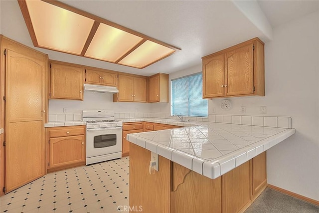 14158 Tu Su Cir, Apple Valley, CA 92307 - kitchen featuring gas range gas stove, under cabinet range hood, a peninsula, tile countertops, and light flooring