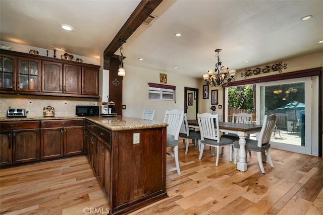 19536 Kittridge St, Reseda, CA 91335 - kitchen featuring black microwave, a chandelier, light wood finished floors, light stone counters, and recessed lighting