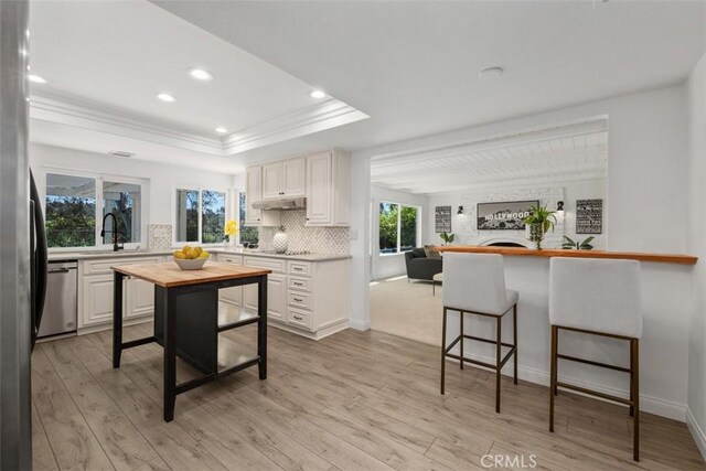 26532 Via Marina, Mission Viejo, CA 92691 - kitchen featuring wood counters, a tray ceiling, stainless steel appliances, tasteful backsplash, and a kitchen bar