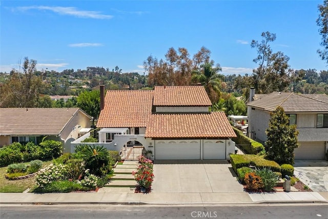 26532 Via Marina, Mission Viejo, CA 92691 - mediterranean / spanish home featuring a tiled roof, concrete driveway, stucco siding, a chimney, and a garage