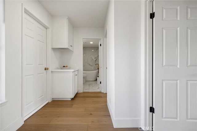 8396 Goldsport Cir, Huntington Beach, CA 92646 - corridor featuring light wood-style flooring and baseboards