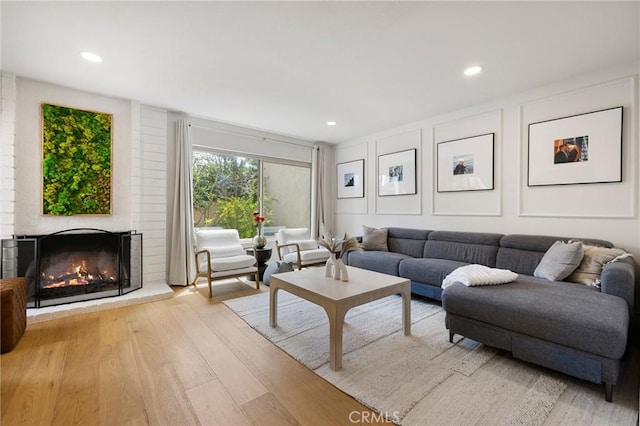 8396 Goldsport Cir, Huntington Beach, CA 92646 - living area with wood finished floors, a brick fireplace, recessed lighting, and a decorative wall