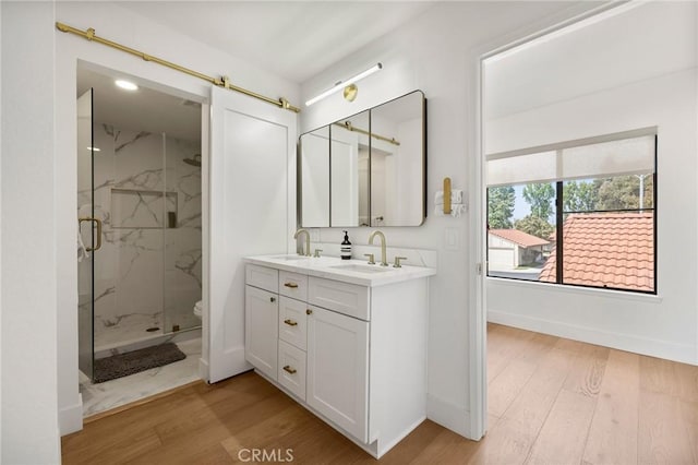 8396 Goldsport Cir, Huntington Beach, CA 92646 - bathroom featuring a marble finish shower, double vanity, and wood finished floors