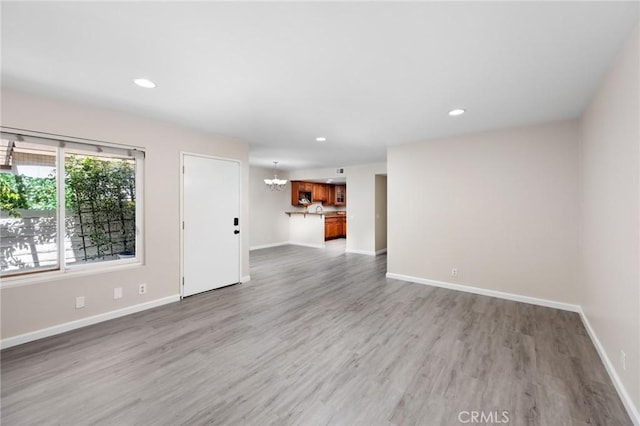 1304 Calle Grande Unit 68, Fullerton, CA 92835 - unfurnished living room featuring a chandelier, light wood finished floors, and recessed lighting
