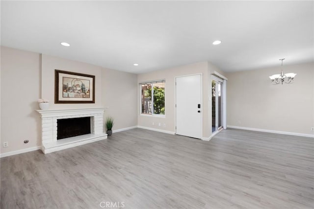 1304 Calle Grande Unit 68, Fullerton, CA 92835 - unfurnished living room with a chandelier, a fireplace, wood finished floors, and recessed lighting