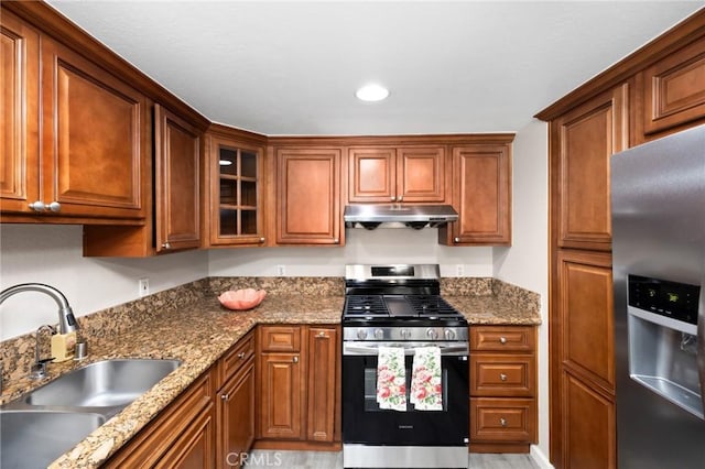 1304 Calle Grande Unit 68, Fullerton, CA 92835 - kitchen with stainless steel appliances, under cabinet range hood, brown cabinetry, glass insert cabinets, and recessed lighting