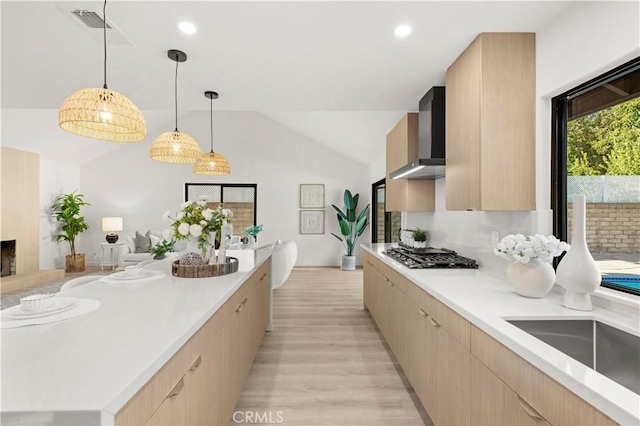 4700 Emerald Ave, La Verne, CA 91750 - kitchen with stainless steel gas stovetop, wall chimney range hood, light brown cabinets, lofted ceiling, and recessed lighting