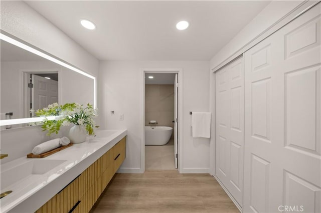 4700 Emerald Ave, La Verne, CA 91750 - full bathroom with double vanity, a freestanding tub, wood finished floors, and recessed lighting