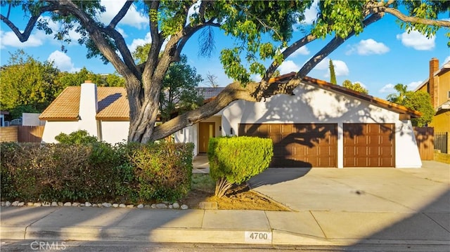 4700 Emerald Ave, La Verne, CA 91750 - mediterranean / spanish-style home featuring a tile roof, an attached garage, stucco siding, driveway, and a chimney