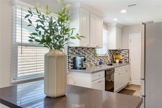 9099 Via Vista Dr, Buena Park, CA 90620 - kitchen with freestanding refrigerator, dishwasher, white cabinetry, decorative backsplash, and recessed lighting