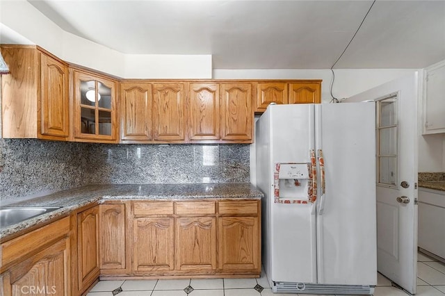 17229 Ardath Ave, Torrance, CA 90504 - kitchen with white refrigerator with ice dispenser, glass insert cabinets, backsplash, and brown cabinetry