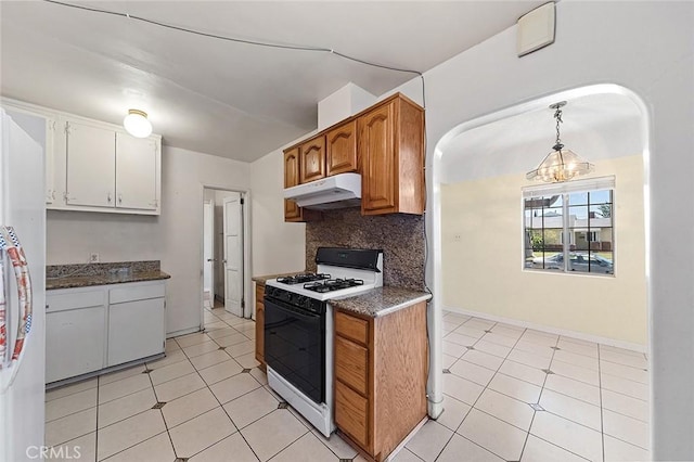 17229 Ardath Ave, Torrance, CA 90504 - kitchen with white range with gas cooktop, under cabinet range hood, dark countertops, decorative backsplash, and freestanding refrigerator