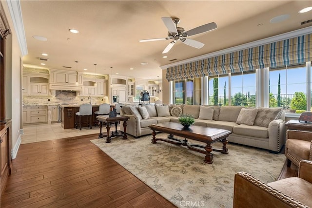44277 Reidel St, Temecula, CA 92592 - living room with ceiling fan, plenty of natural light, crown molding, recessed lighting, and light wood-style flooring