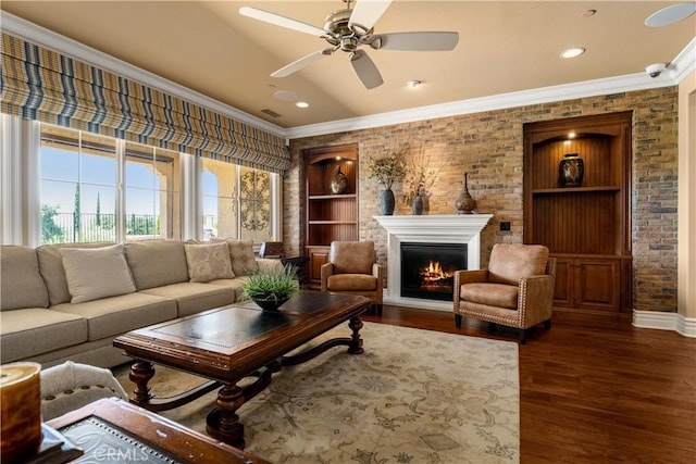 44277 Reidel St, Temecula, CA 92592 - living area with ornamental molding, dark wood-type flooring, a warm lit fireplace, ceiling fan, and recessed lighting