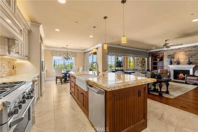 44277 Reidel St, Temecula, CA 92592 - kitchen with appliances with stainless steel finishes, crown molding, brown cabinets, a ceiling fan, and light stone counters