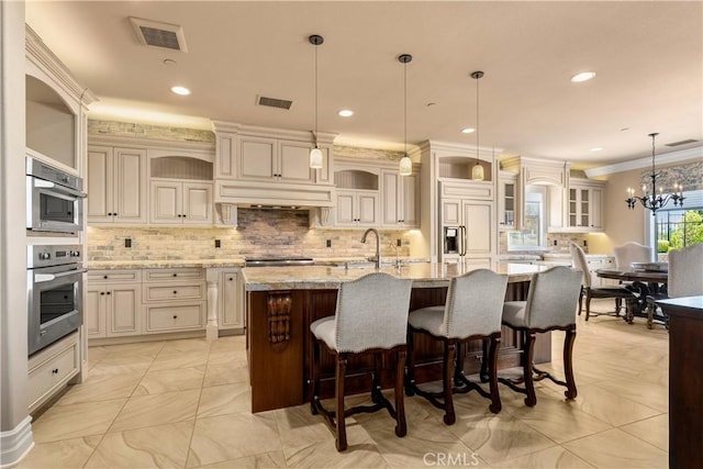 44277 Reidel St, Temecula, CA 92592 - kitchen featuring tasteful backsplash, paneled fridge, a kitchen island with sink, light stone counters, and glass insert cabinets
