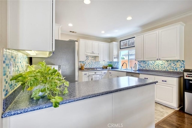 32839 Tiempo Cir, Temecula, CA 92592 - kitchen featuring ornamental molding, stainless steel appliances, dark countertops, a peninsula, and tasteful backsplash