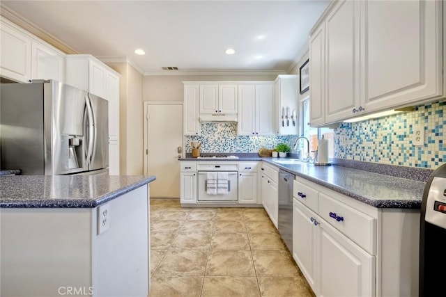 32839 Tiempo Cir, Temecula, CA 92592 - kitchen with appliances with stainless steel finishes, white cabinets, tasteful backsplash, crown molding, and under cabinet range hood